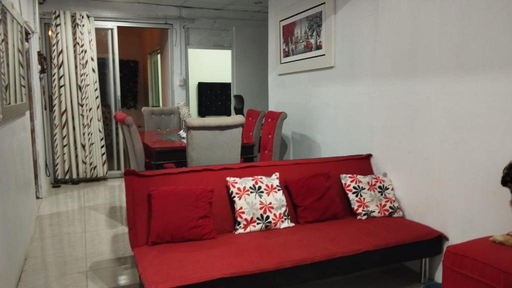 a red couch with pillows in a living room at BOLOGNESI in Huarmey