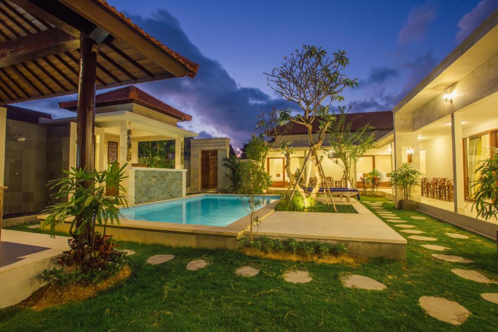 a house with a swimming pool in a yard at Canggu Bagus in Canggu