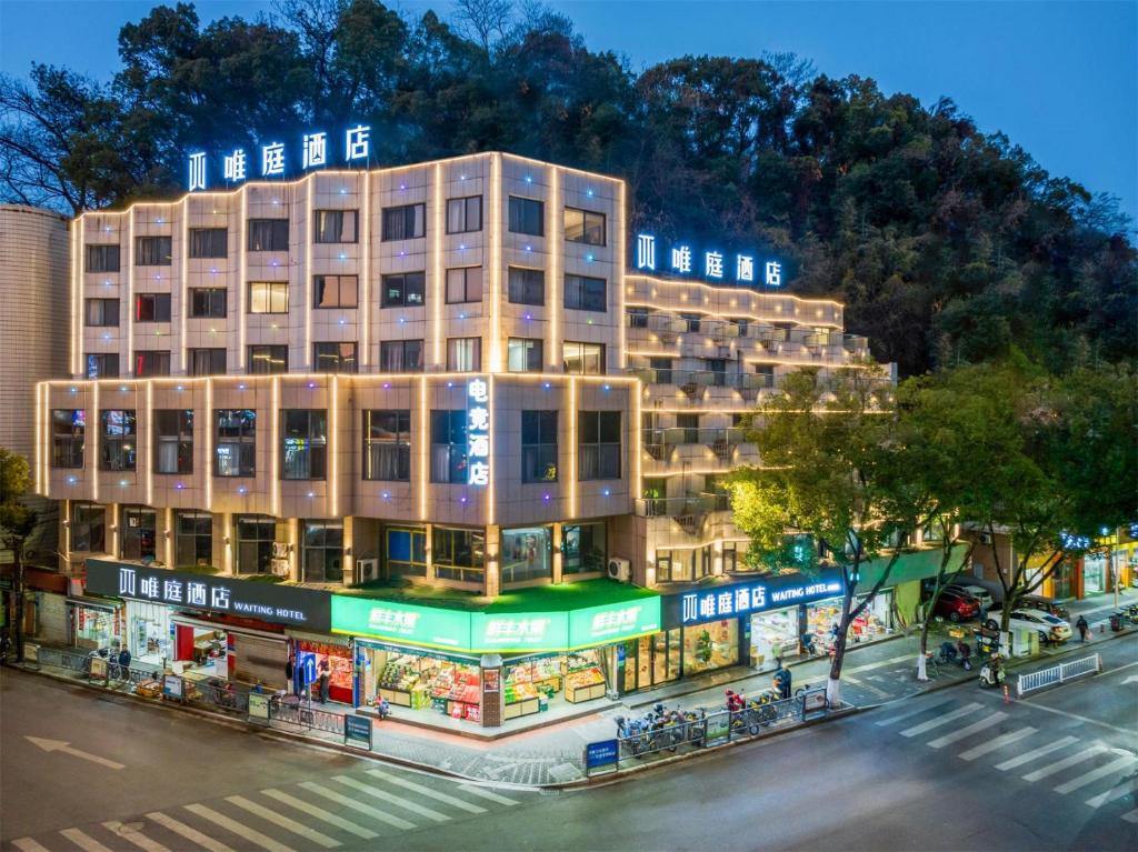 um edifício numa rua em frente a uma loja em Waiting Hotel - Jiande Xin'an River Riverside em Jiande