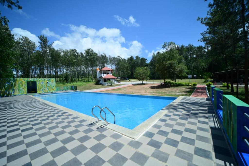 a swimming pool with a tiled floor at SIPAYI RESORT COORG in Kushālnagar