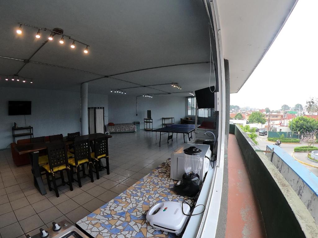 a room with a balcony with a table and chairs at Departamento Loft equipado, céntrico y cómodo in Xalapa