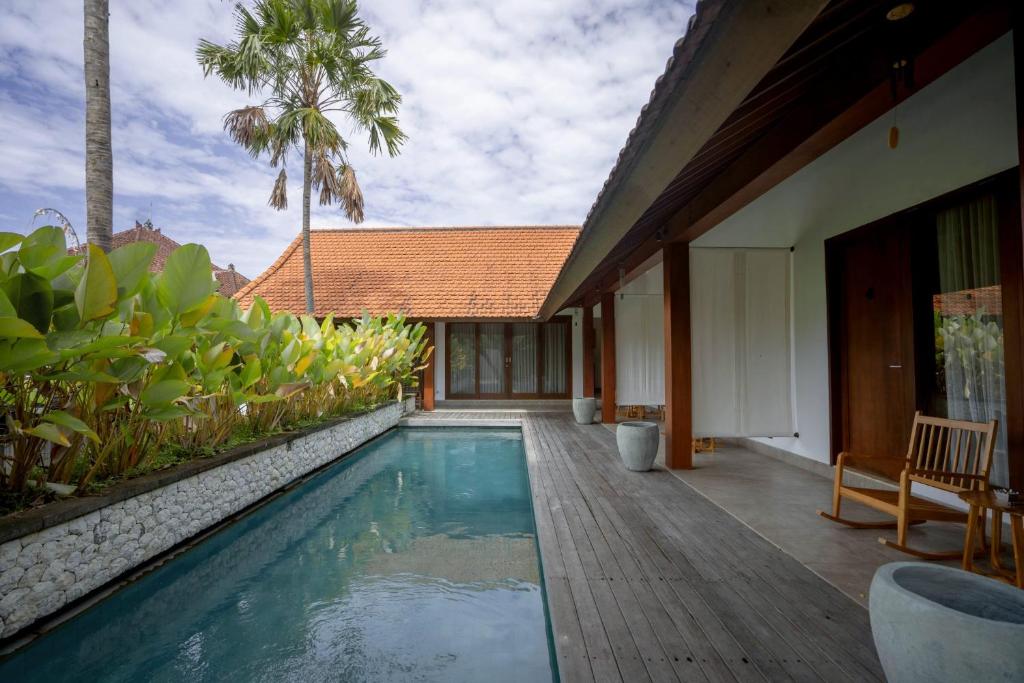 uma villa com uma piscina e uma casa em Rarama Living Studio em Kerobokan