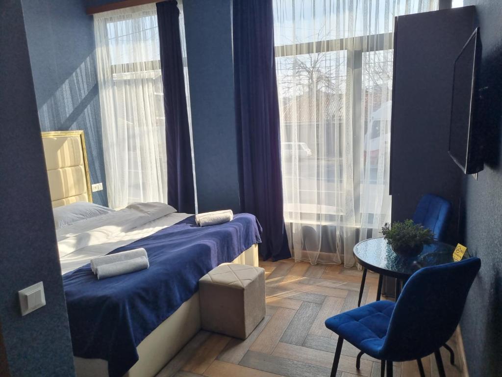 a bedroom with a bed and a table and a window at Dayssin Boutique hotel in Yerevan