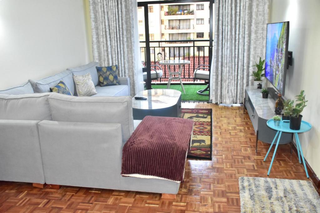 a living room with a couch and a table at Wills House, Three Bedroom with Extra Bed in Kilimani in Nairobi