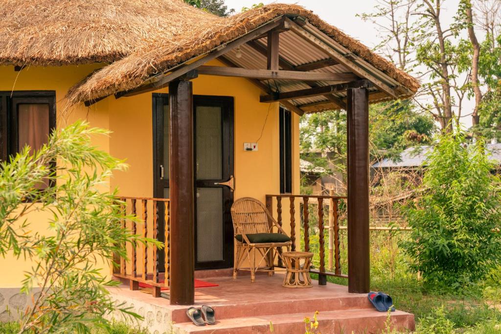 mały żółty dom z dachem krytym strzechą w obiekcie Sunsetview Bardia w mieście Bardia