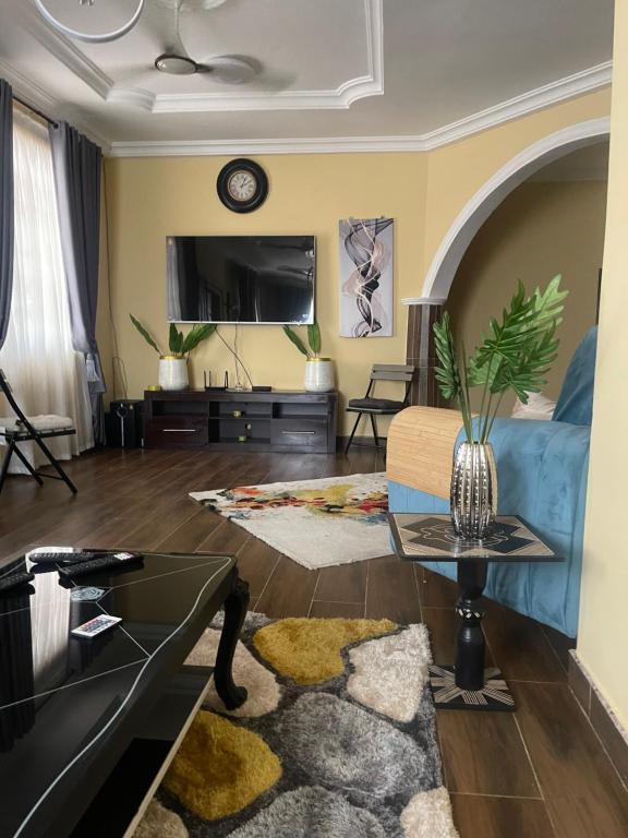 ein Wohnzimmer mit einem Sofa und einem TV in der Unterkunft Coolzzy GM247 Homes-Accra Kwabenya Villas in Accra