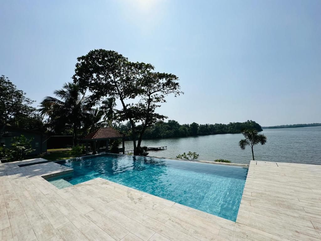 a swimming pool next to a body of water at The Niche Hikkaduwa - 10 minutes to the beach in Hikkaduwa