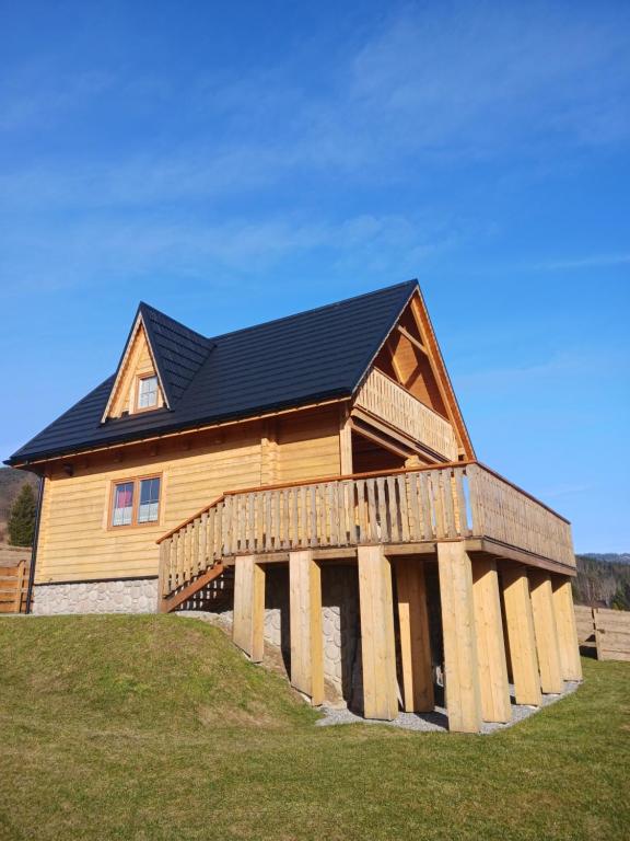 een groot houten huis met een zwart dak bij Hasiorówka. Dom w górach in Złatna
