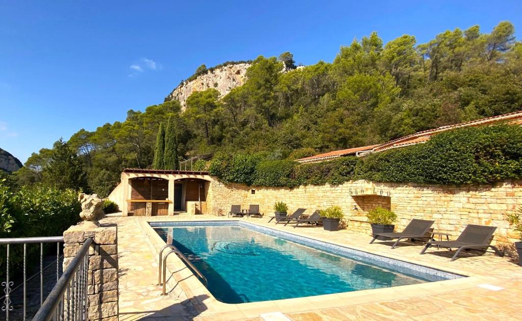 una piscina accanto a un edificio con montagna di Le Mas de San Lou a Cabasse