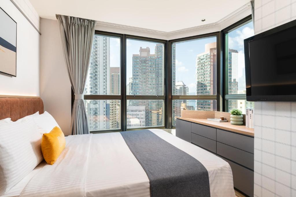 een slaapkamer met een groot bed en een groot raam bij Dash Living on Hollywood in Hong Kong