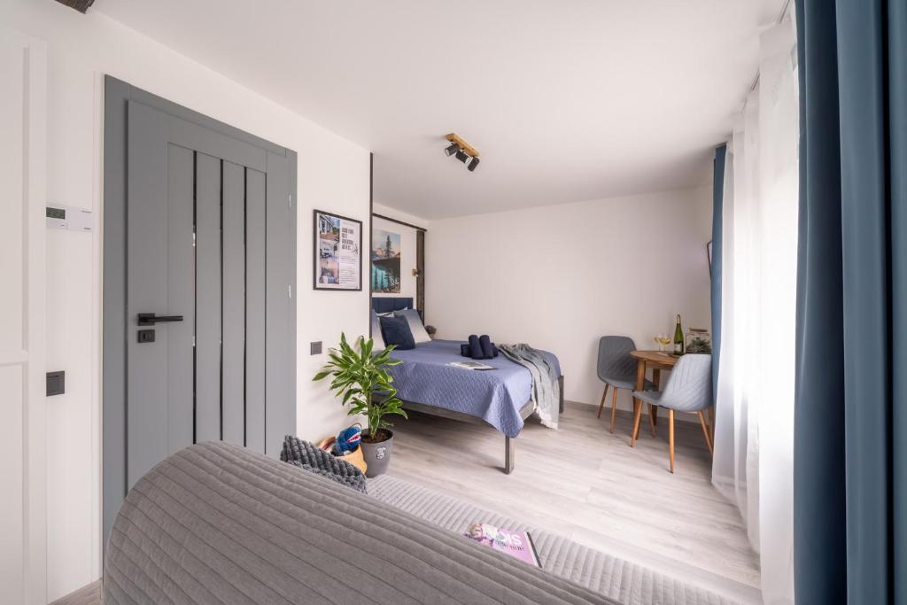 sypialnia z łóżkiem i stołem w pokoju w obiekcie Green Garden & Parking Apartments w Rydze