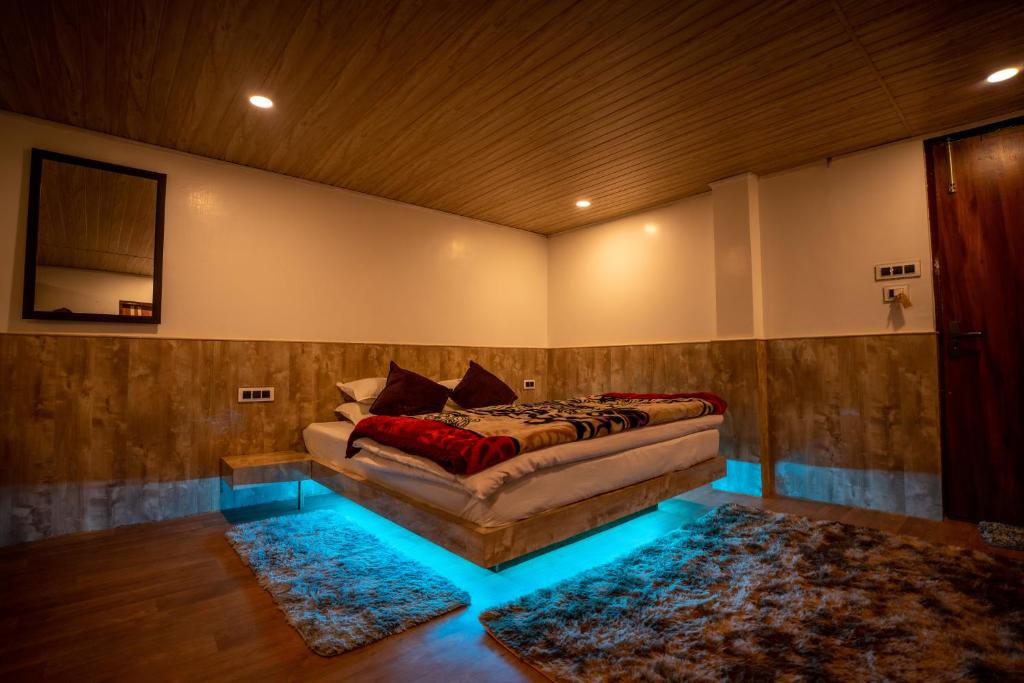 - une chambre avec un lit dans une pièce dotée de lumières bleues dans l'établissement Darjeeling Guest House Deluxe, à Darjeeling