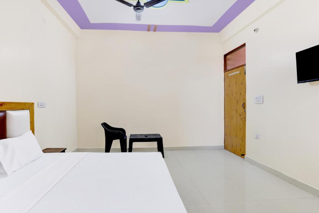 a bedroom with a bed and two black chairs at Super OYO Hotel Blu Moon in Ghaziabad
