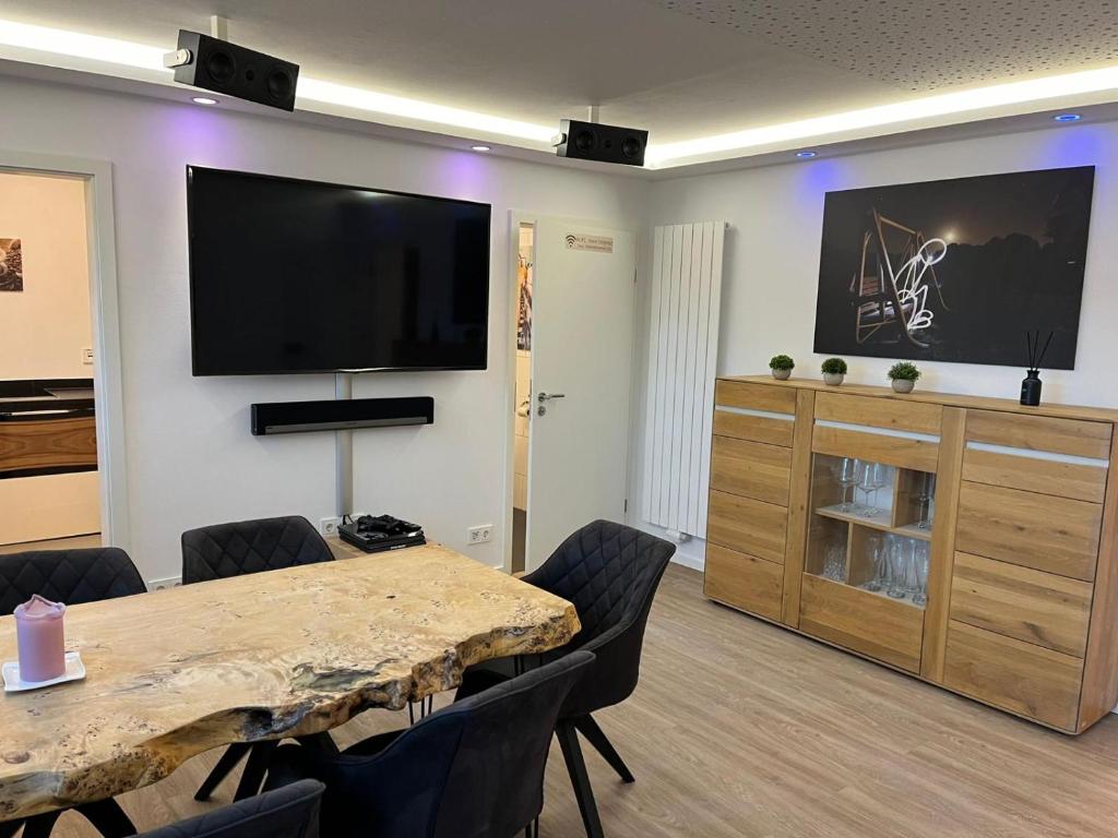 a conference room with a table and a flat screen tv at Porschenahe Wohung in Stuttgart