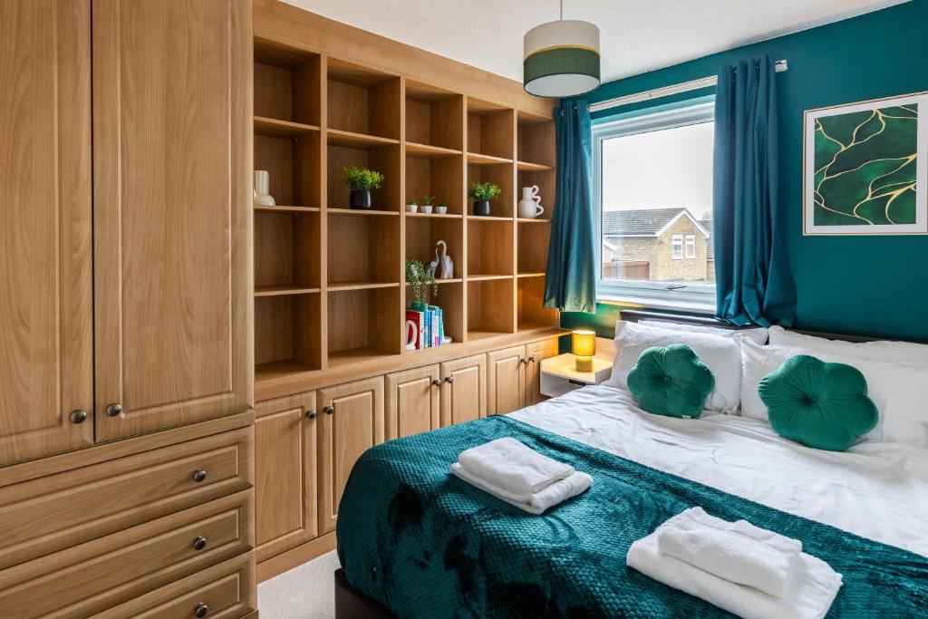 Un dormitorio con una cama con paredes azules y una ventana en Thames, Cambridge - Long stay - Contractors - Relocators, en Cambridge