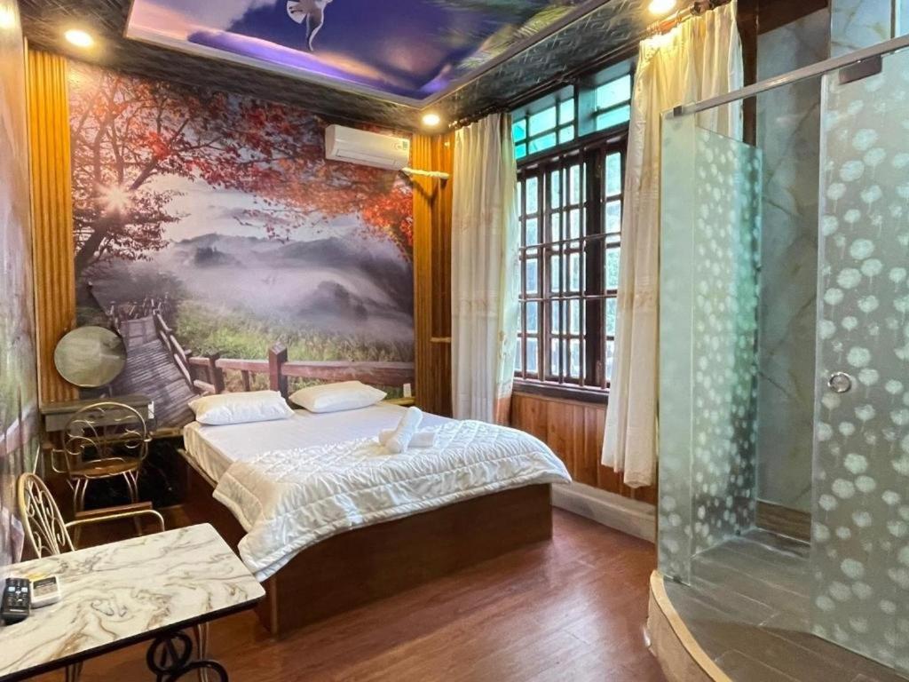 Hoàng Gia Hotel - 1224 CMT8 Bình Dương - by Bay Luxury في Ấp Phú Thọ: غرفة نوم بسرير ودهان على الحائط