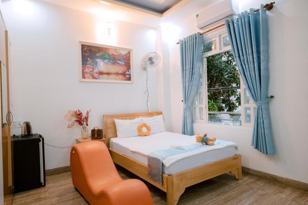 ein Schlafzimmer mit einem Bett, einem Stuhl und einem Fenster in der Unterkunft Calido Hotel Vung Tau in Xã Thang Tam
