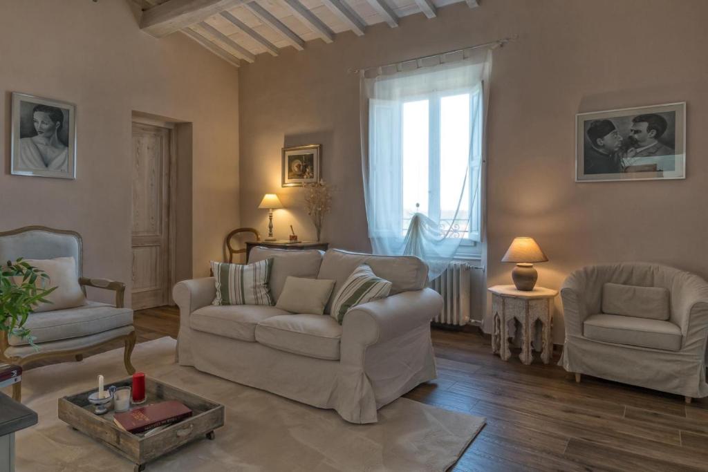 ein Wohnzimmer mit einem Sofa, 2 Stühlen und einem Fenster in der Unterkunft Casa Cantagalli in Tavarnuzze