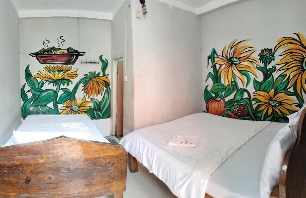 Zimmer mit 2 Betten und Wandgemälde in der Unterkunft Sunflower Guesthouse Koh Rong in Phumĭ Kâoh Rŏng