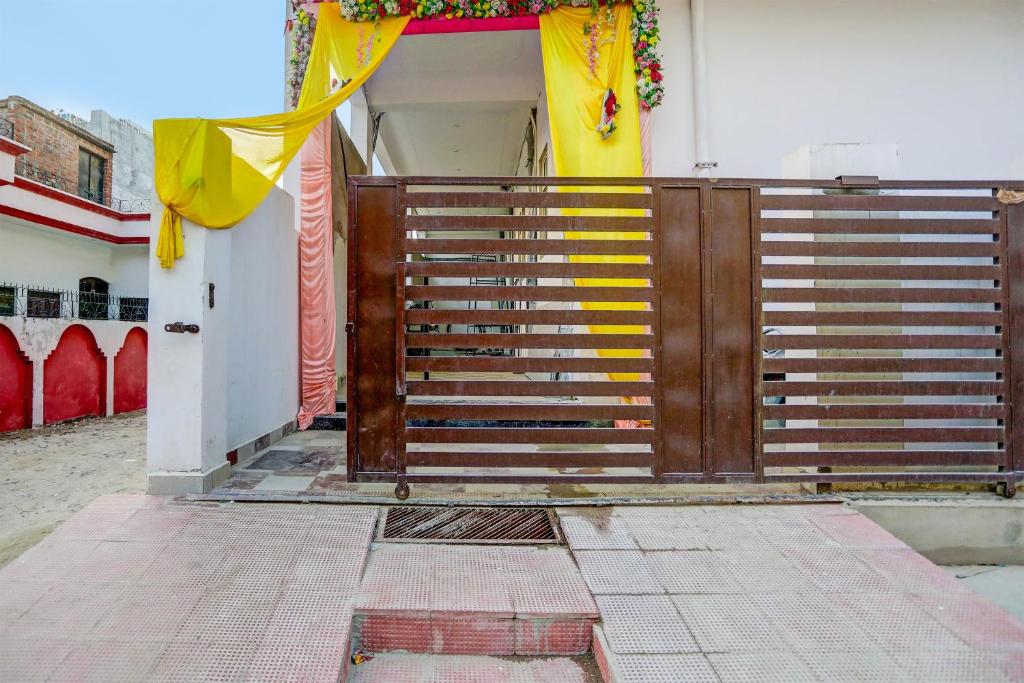 a wooden gate to a house with a yellow curtain at Super OYO Flagship A R V Palace in Lucknow