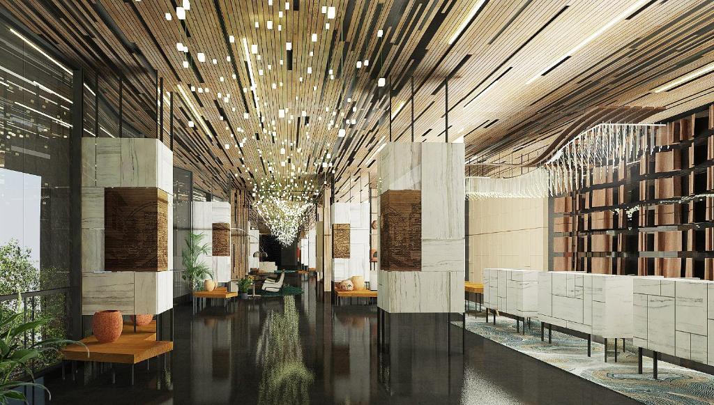 Mövenpick Hotel Jakarta City Centre في جاكرتا: لوبي فيه طاولات وكراسي في مبنى