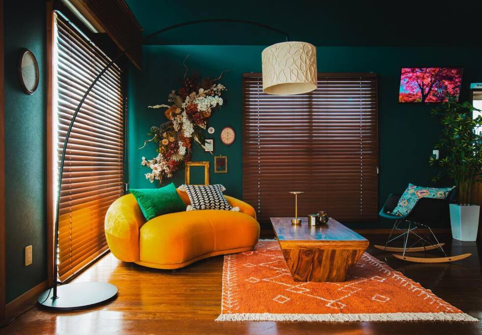 a living room with a yellow couch and a table at The Archaic / Luxury apartment near Shinjuku in Tokyo