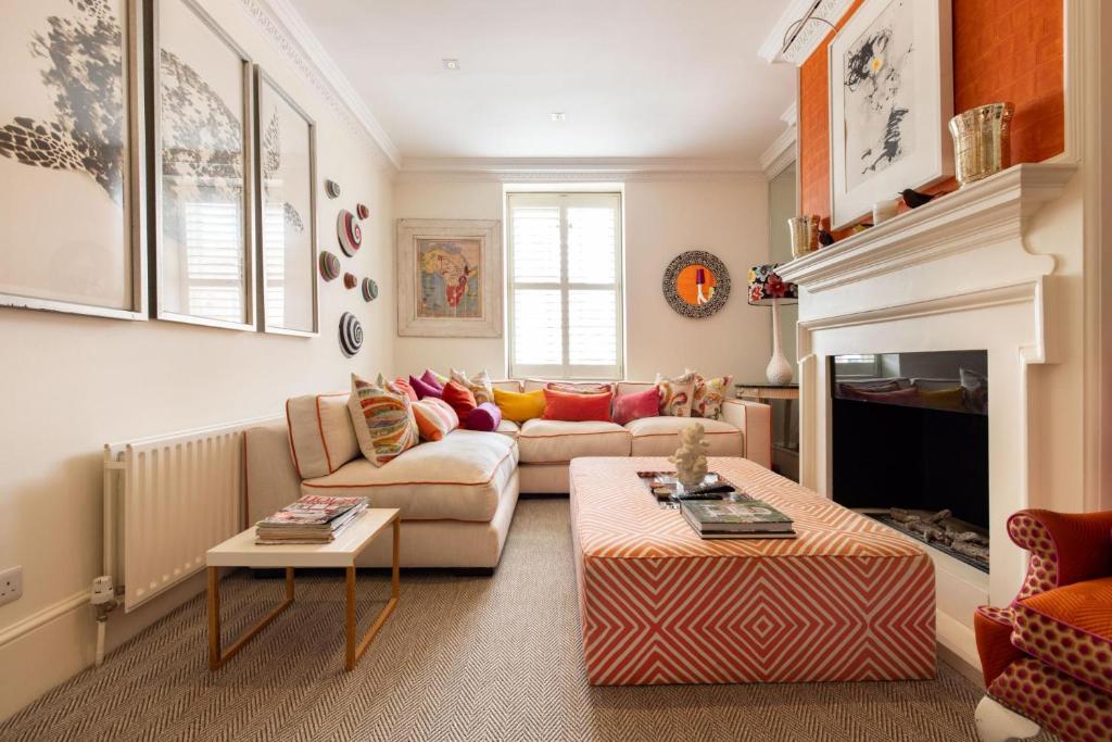 a living room with a couch and a fireplace at A Royal Residence – Stylish 2 Bedroom in Kensington in London