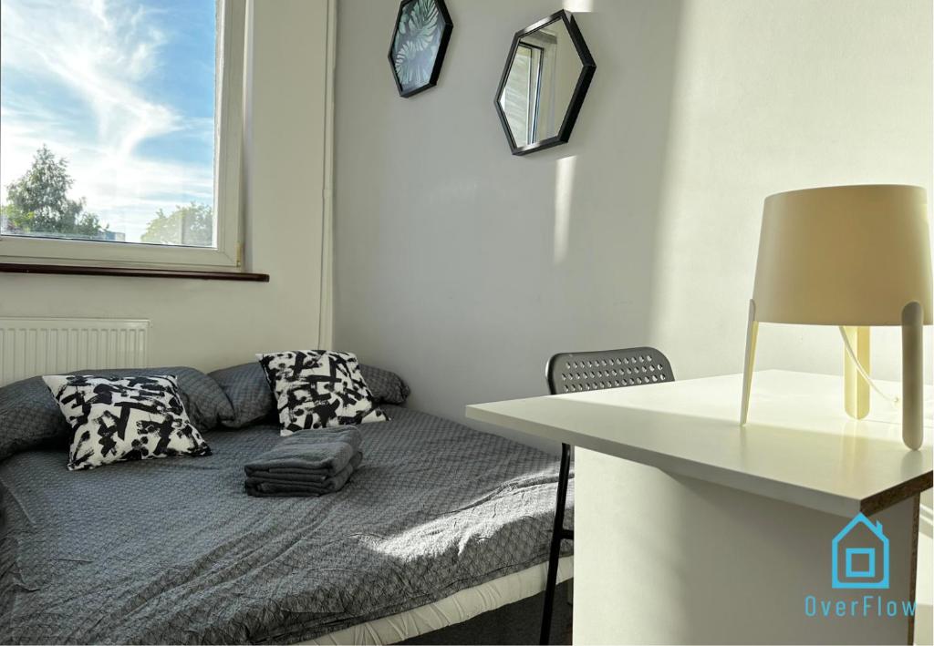 Habitación con cama y mesa con lámpara. en Lambert Room en Gdansk