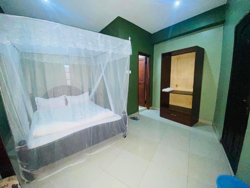 een slaapkamer met een bed met een klamboe bij Suzie hotel Kampala Uganda old twon in Kampala