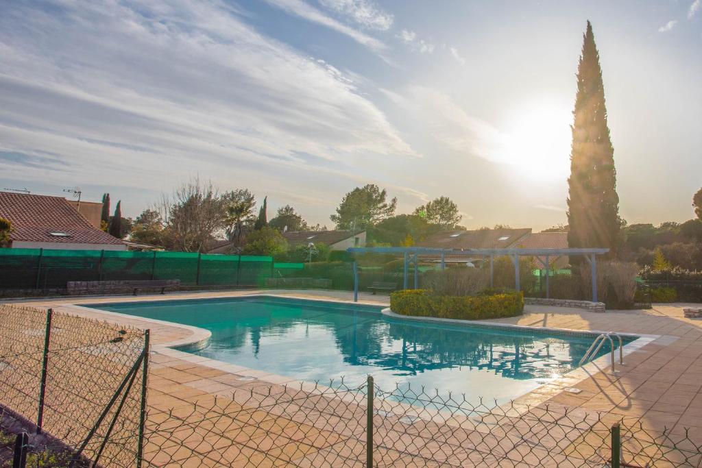 una piscina en un patio con una valla en Joli Mazet indépendant, en La Motte