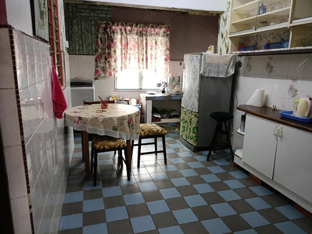 a small kitchen with a table and a kitchen with a refrigerator at Homestay Bemban Batu Gajah in Batu Gajah