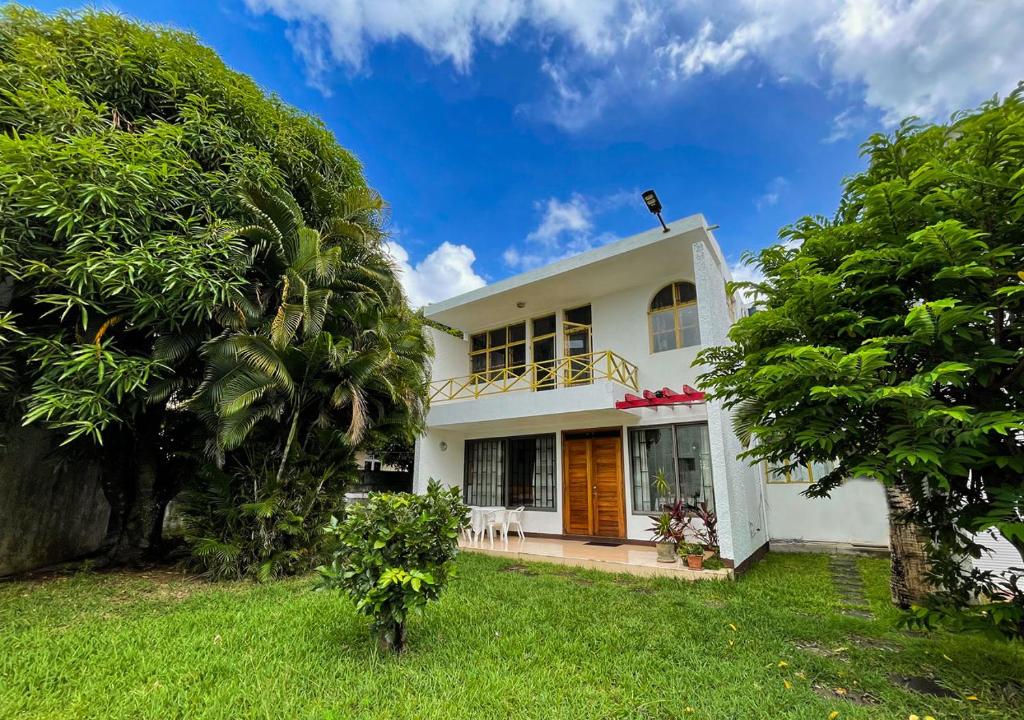 a white house with trees in front of it at 3 bedroom Villa - Private and Spacious in Pointe aux Canonniers