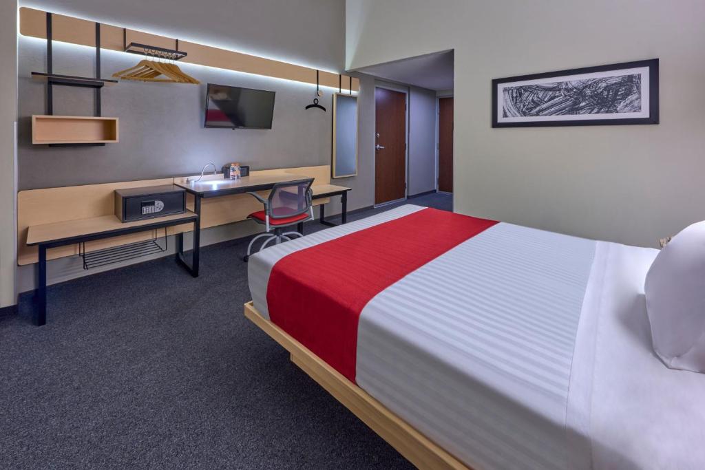 A double room with a long work surface, open hanging rail and wall-mounted television.