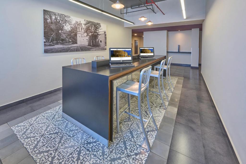 A hotel lobby work counter with two computers and high stools.