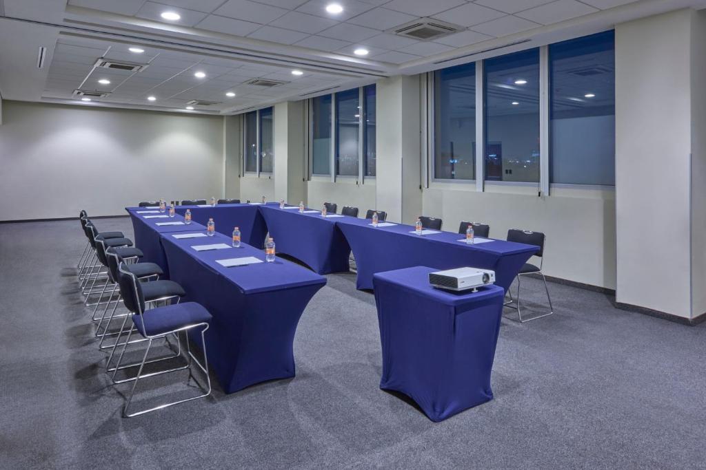 A blue-draped meeting room set in a U-shaped conference layout.