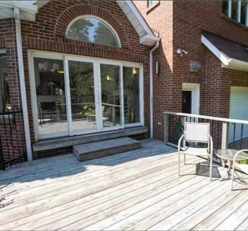 a wooden deck with a large window on a building at Beautiful Private Room Near Restaurants Shopping and Transit P1 in Pickering