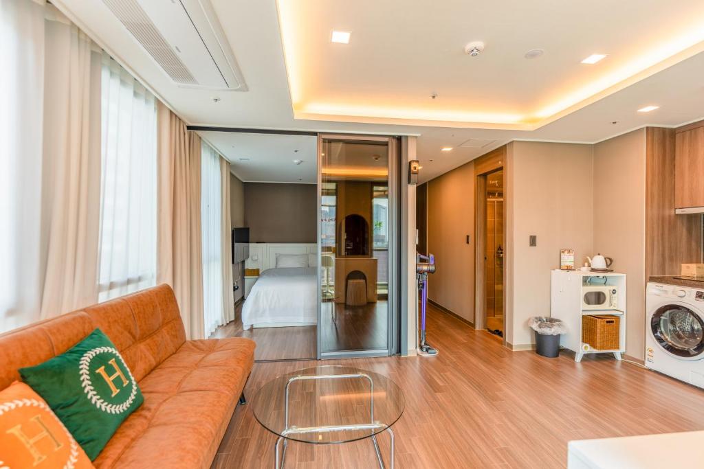 a living room with a couch and a bed at Haeundae Family Hotel ARBOL Sunny#ocean view in Busan