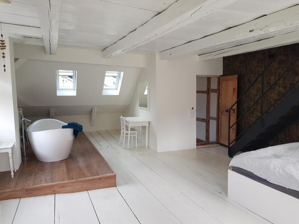 sypialnia z dużym łóżkiem i drewnianą podłogą w obiekcie Historisch grosszügiges Haus w mieście Glarus