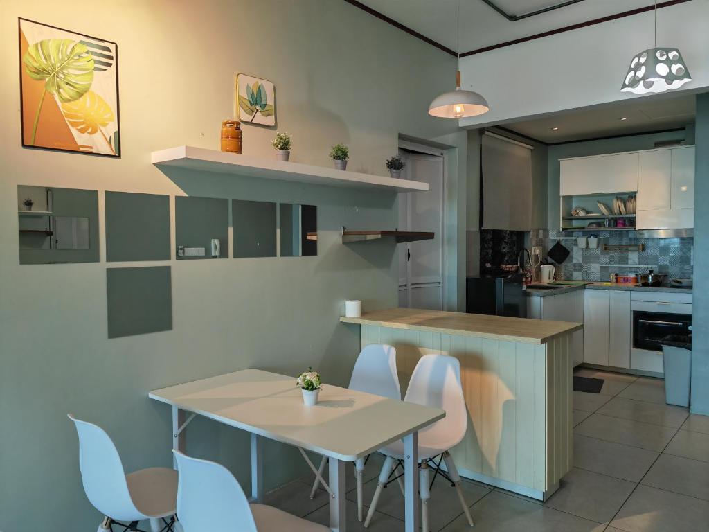 une cuisine avec une table, des chaises et un comptoir dans l'établissement Modern Comfy Suite Room-9Pax, à Perai