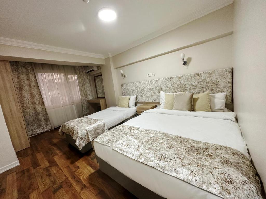 イスタンブールにあるAntik Ipek Suitのベッド2台と窓が備わるホテルルームです。