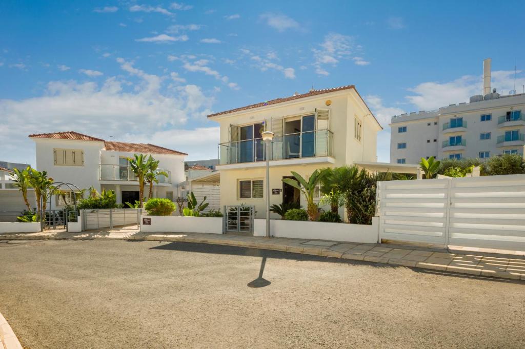 una casa con una staccionata bianca in un parcheggio di Villa Athena a Protaras