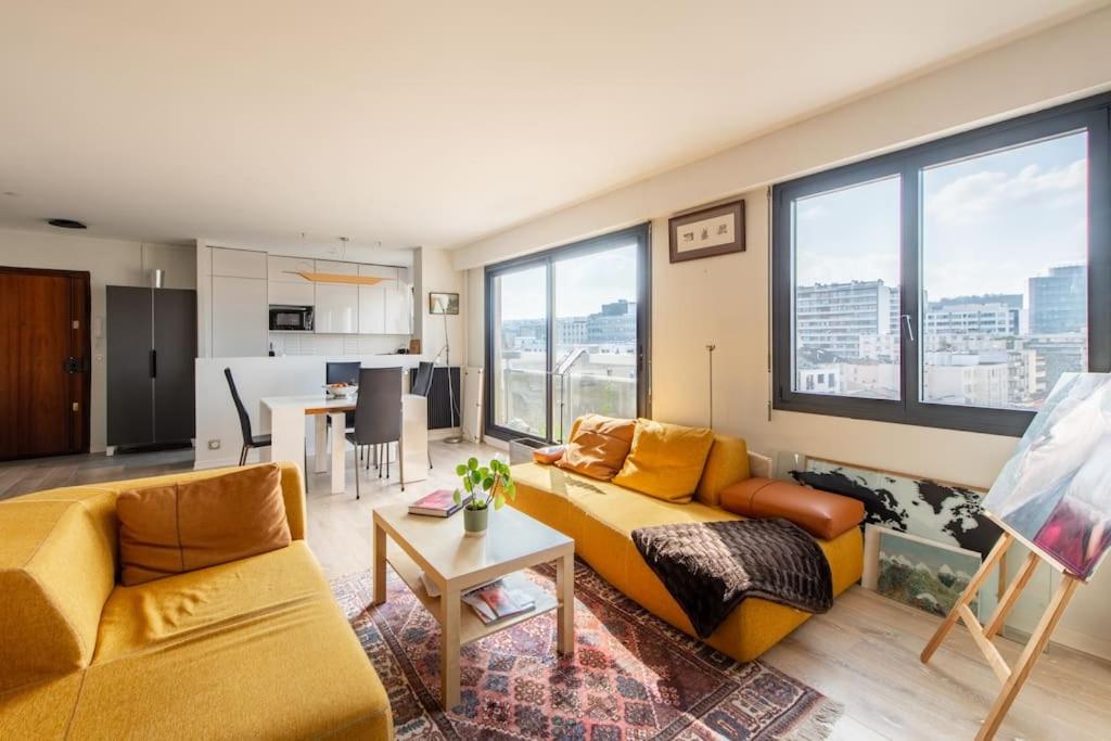 ein Wohnzimmer mit einem Sofa und einem Tisch in der Unterkunft Bellevue - Superbe appartement avec vue, à pont de Sèvre in Boulogne-Billancourt