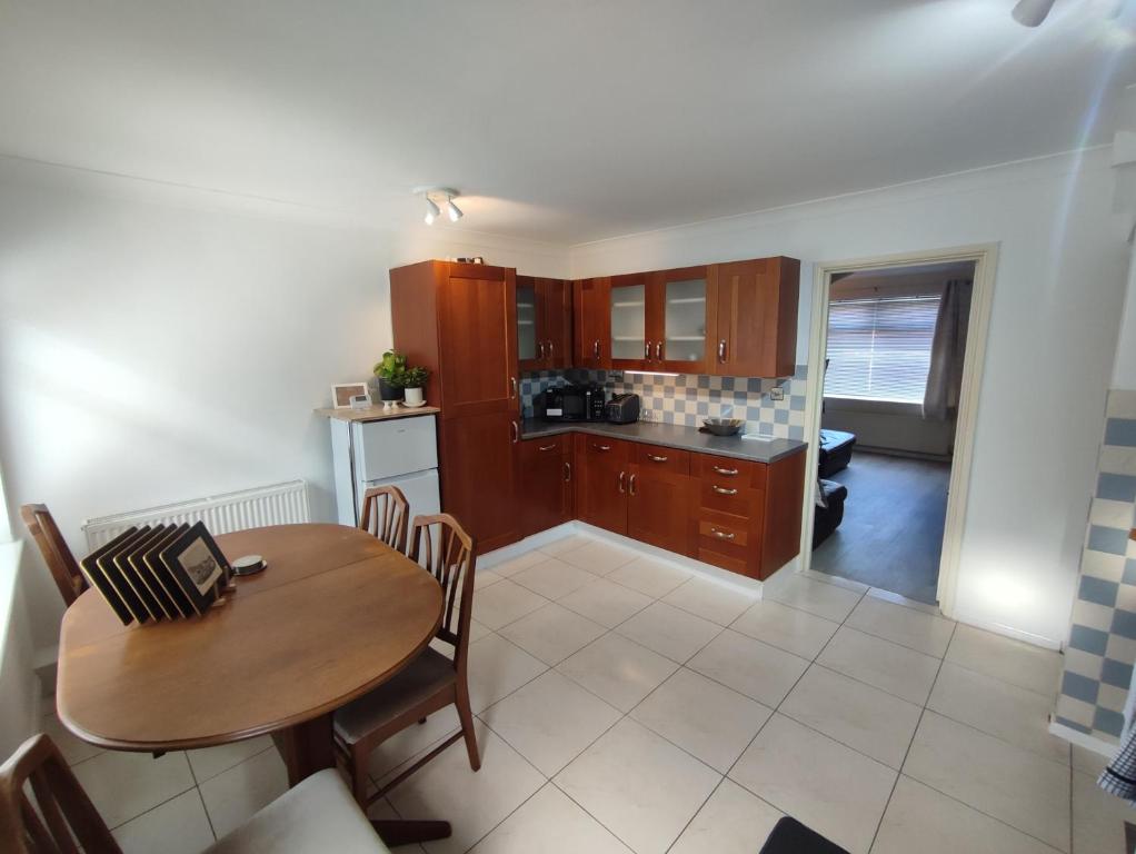 cocina con mesa de madera y comedor en Sheffield meadowhall interchange house with off street parking en Sheffield