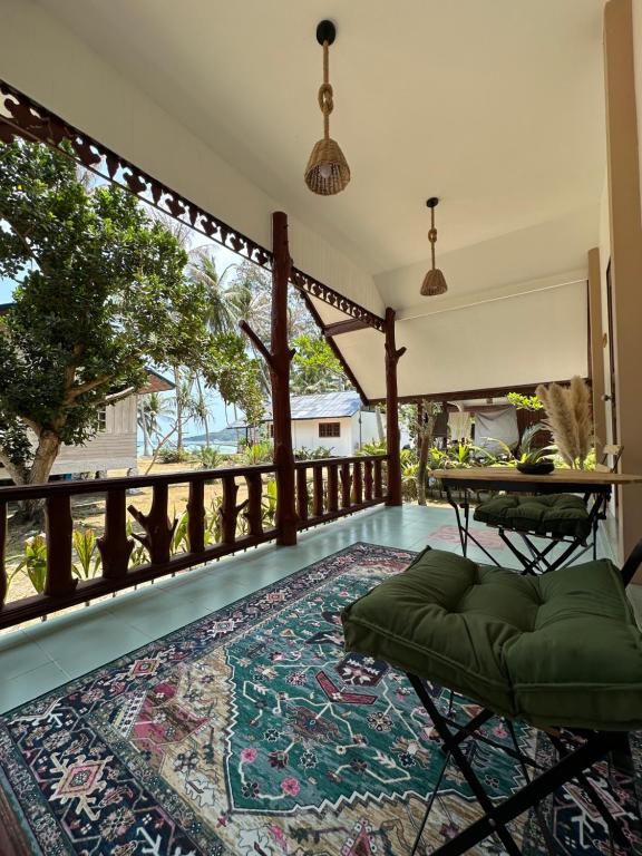 - Balcón con mesa y alfombra en Cozy house in Chaloklum, en Mae Haad