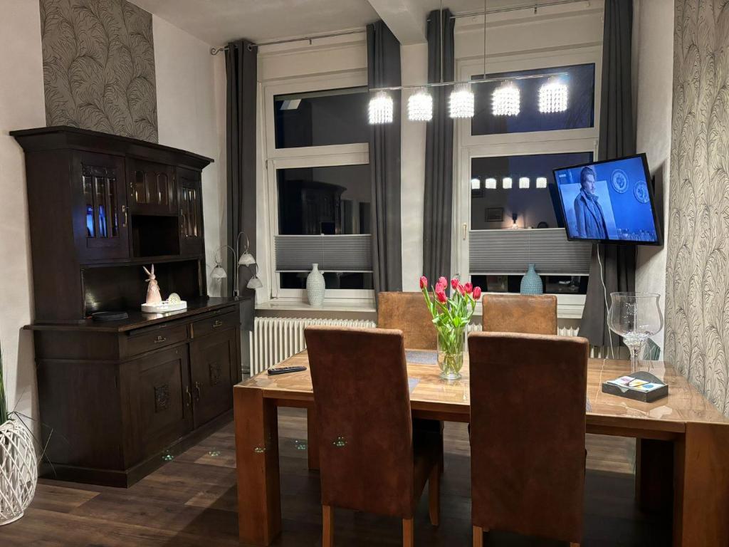 a dining room with a wooden table and a television at Fewo Nähe Norddeich/ Nessmersiel in Hagermarsch