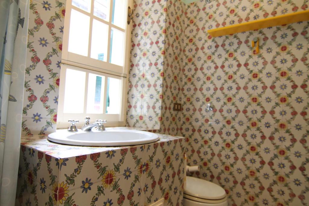 łazienka z umywalką, toaletą i oknem w obiekcie Five Lands Pink Cottage w mieście Levanto