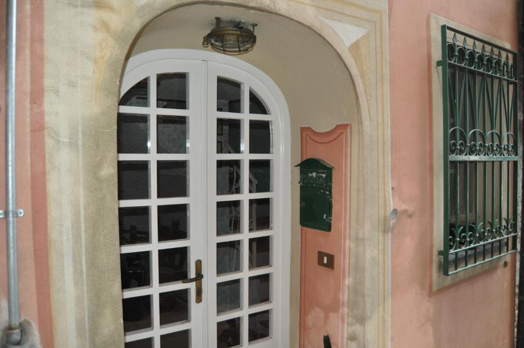 una entrada a una casa con una puerta blanca en Five Lands Pink Cottage, en Levanto