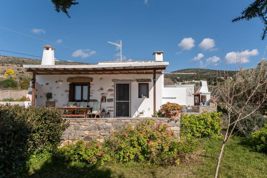 a small white house with a stone wall at Savvas's Traditional House Paros in Episkopianá