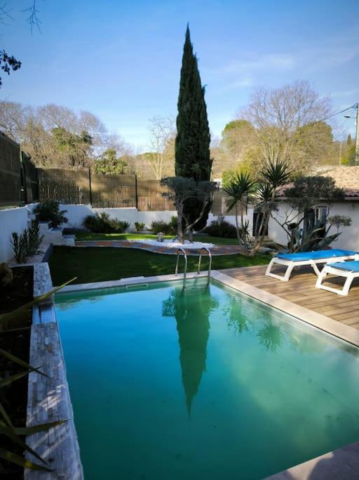 une grande piscine bleue dans une cour dans l'établissement Au Petit Mazet - 4 personnes, à Nîmes