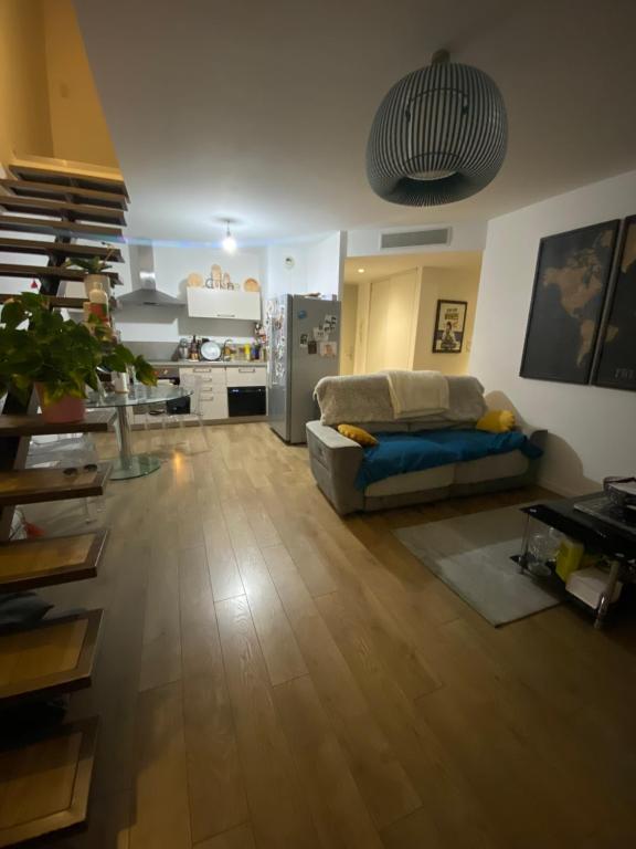 un salon avec un canapé et une cuisine dans l'établissement Appartement centre ville, à Corte